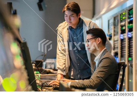 一名中年男子和一名年輕男子在電視台從事錄像製作。拍攝合作:Sky Perfect電視台東京媒體中心 一名中年男子和一名年輕男子在電視台從事錄像製作。拍攝合作:Sky Perfect電視台東京媒體中心 125069305