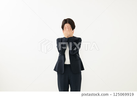 A woman hiding her face A woman hiding her face 125069919