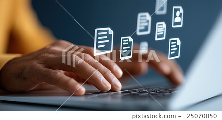 person typing on laptop with floating digital document icons, symbolizing online forms 125070050