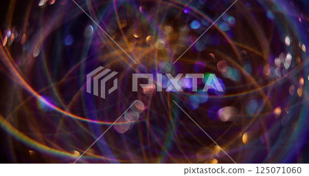 Kaleidoscope rays. Defocused light flares. Sparkling purple color particles lens flash motion on blurred background with bokeh effect. 125071060