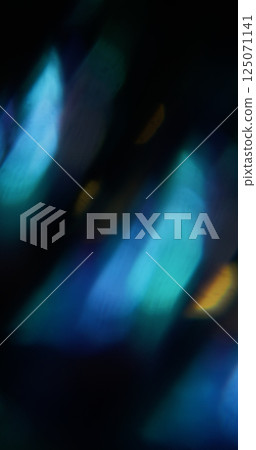 Light shine. Blur visual flare. Defocused blue green yellow colorful lens sparkle texture on abstract dark black background. 125071141