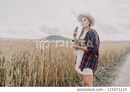 Woman in a Wheat Field Holding a Microphone and Tablet 125071219