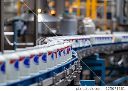 Plastic bottles with milk moving on conveyor belt at dairy factory, industrial automated food production line 125071661