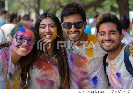 Four friends covered with colored powder are smiling during holi festival celebration 125071707