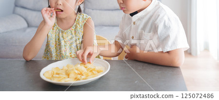 Child eating potato chips snack Child eating potato chips snack 125072486