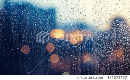 Water droplets on a window pane on a rainy day and blurred natural scenery Emotional background 125072767