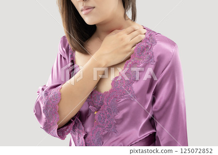 Woman scratches shoulder and neck due to irritation. 125072852
