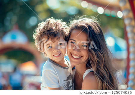 Mother and her son are enjoying a sunny day at an amusement park, smiling and creating lasting memories 125074086