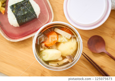 午餐時用湯罐盛著熱騰騰的味噌湯和飯糰 125075673