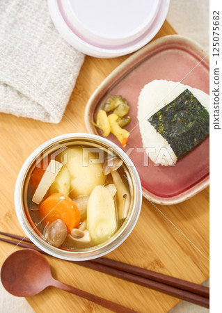 午餐時用湯罐盛著熱騰騰的味噌湯和飯糰 午餐時用湯罐盛著熱騰騰的味噌湯和飯糰 125075682
