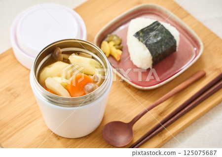 午餐時用湯罐盛著熱騰騰的味噌湯和飯糰 125075687