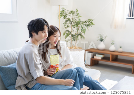 Couples relaxing watching videos and TV Couples relaxing watching videos and TV 125075831