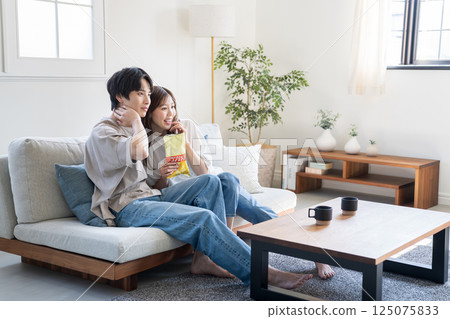 Couples relaxing watching videos and TV 125075833