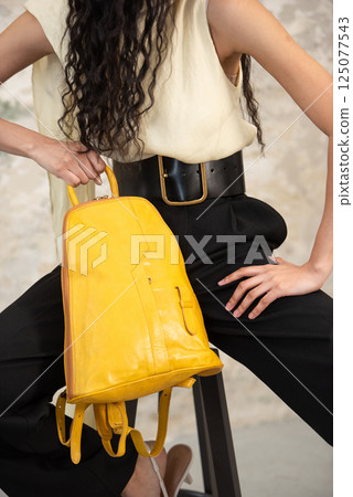 A Chic Outfit Featuring a Bright Yellow Backpack Paired with Stylish and Trendy Pants 125077543