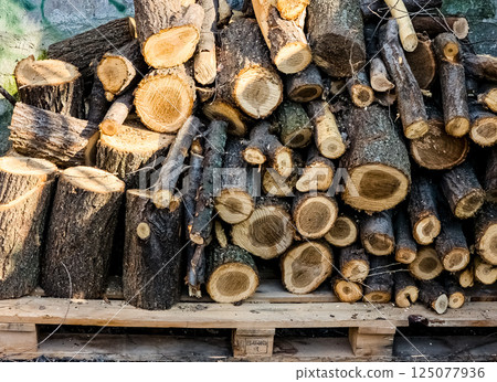 A small pile of firewood stacked on top of each other, firewood on a pallet. A small pile of firewood stacked on top of each other, firewood on a pallet. 125077936