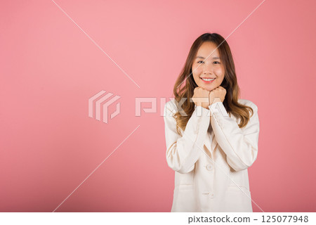 Asian happy portrait beautiful young woman standing smiling surprised excited her keeps hands pressed together under the chin studio shot on pink background with copy space for text Asian happy portrait beautiful young woman standing smiling surprised excited her keeps hands pressed together under the chin studio shot on pink background with copy space for text 125077948