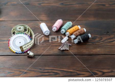 Various threads on the table. Threads and needles on the table. Sewing items on the table. 125078507