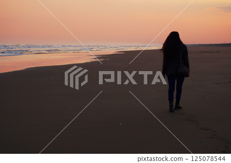 走在海灘的婦女在黃昏 125078544