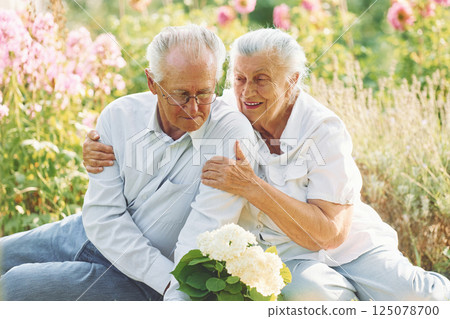 Sitting on the ground. Lovely senior couple is in the garden together 125078700