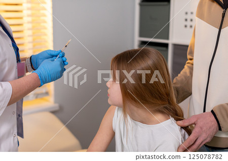 A child is receiving an important vaccination from a qualified healthcare professional 125078782