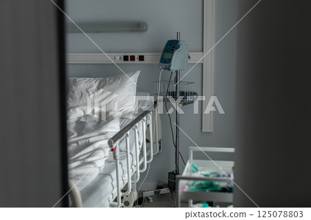 A Hospital Bed equipped with Medical Equipment in a WellOrganized Clinical Setting 125078803