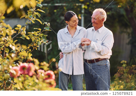 Conception of love. Embracing each other. Daughter is with her senior father in the garden at daytime 125078921