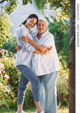 Conception of love to a parent. Young woman is with her senior mother is in the garden 125078968