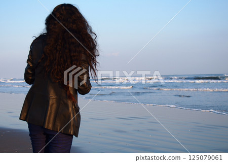 黃昏時分，一位孤獨的女人凝視著大海 125079061