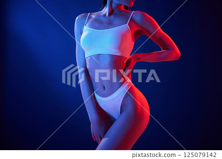 Close up view. Young woman in underwear is in the studio with neon lights 125079142