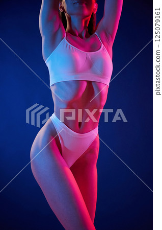 Young woman in underwear is in the studio with neon lights 125079161