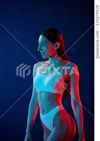 White underwear. Young woman is in the studio with neon lights 125079320