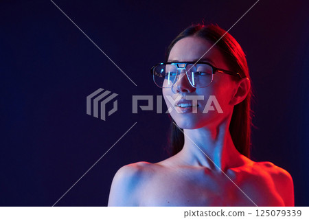 Beautiful look. Portrait of young woman that is indoors in neon lighting 125079339