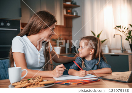 Learning how to draw. Young mother with her daughter is together at apartment 125079588
