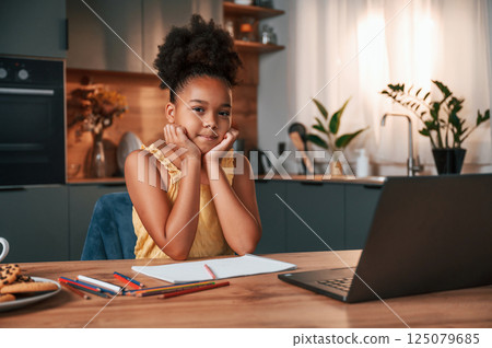 Cute black girl in casual clothes is at home at daytime 125079685