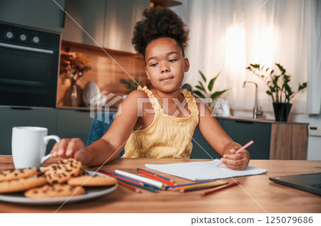 Cute black girl in casual clothes is at home at daytime 125079686