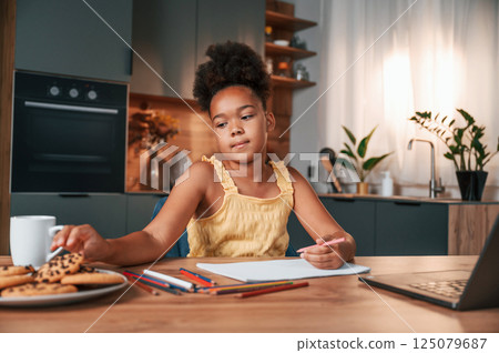 Cute black girl in casual clothes is at home at daytime 125079687