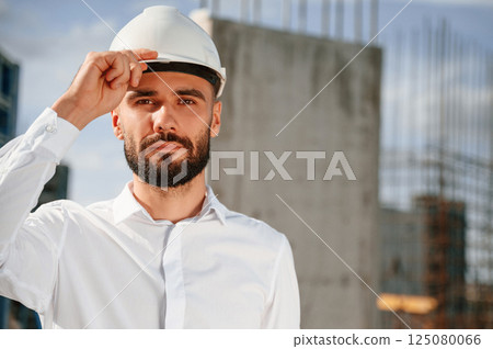 Portrait of man that is in uniform on the construction site Portrait of man that is in uniform on the construction site 125080066