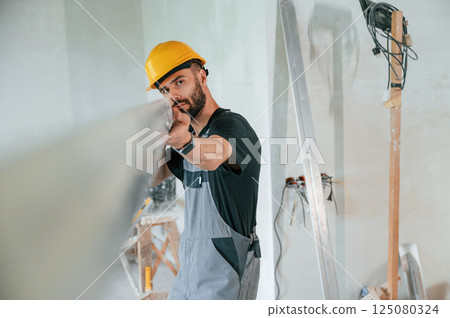 Holding construction material stuff by hands. The man is making repairs in the apartment Holding construction material stuff by hands. The man is making repairs in the apartment 125080324