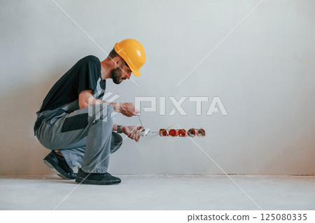 Repairs sockets. The man is in the apartment 125080335