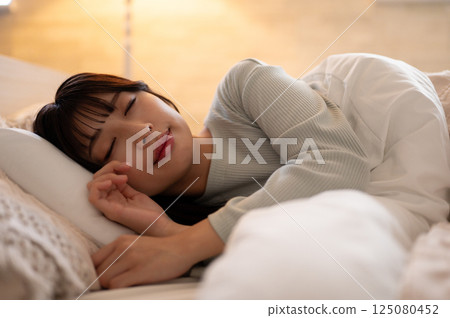 一個睡在床上的年輕女人 一個睡在床上的年輕女人 125080452