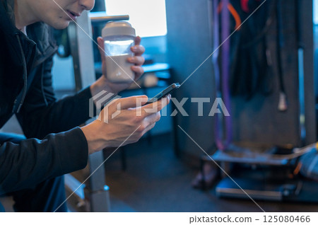 A man using a smartphone at the gym 125080466