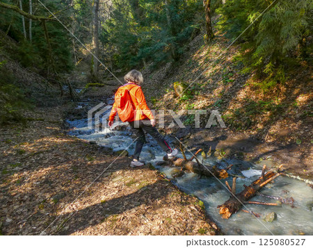 Crossing a mountain stream active lifestyle Crossing a mountain stream active lifestyle 125080527