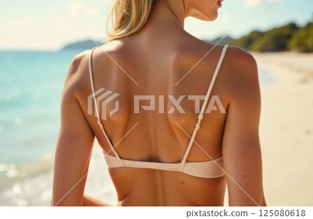 Young attractive blonde girl with perfect sport body in bikini on the tropical summer beach 125080618