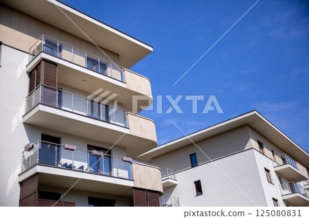 A Modern Residential Building Featuring Stylish Balconies Under a Clear, Bright Blue Sky 125080831