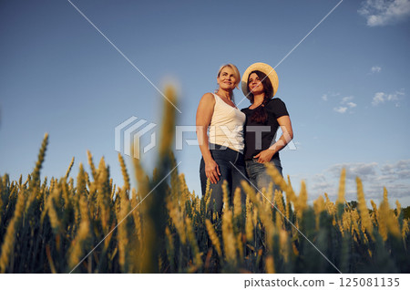 Two women standing on the agriculture field with growing wheat Two women standing on the agriculture field with growing wheat 125081135