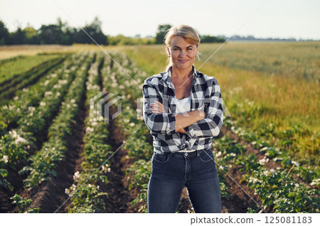 Standing and posing. Woman is on the agricultural field at daytime Standing and posing. Woman is on the agricultural field at daytime 125081183