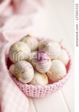 Solo glove garlic bulbs in bowl on white table. Solo glove garlic bulbs in bowl on white table. 125081328