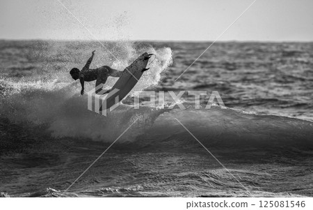 Fantastic Surfer Water Splash and Surfer Jump  He Seemed to be Hanging in the Air (Unrecognizable Person). 125081546