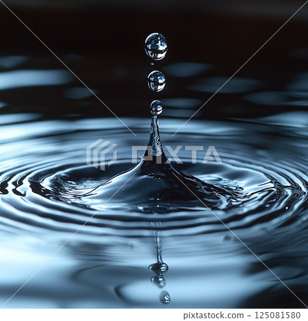 Captivating macro shot showing water droplets creating ripples on the tranquil water surface. Captivating macro shot showing water droplets creating ripples on the tranquil water surface. 125081580