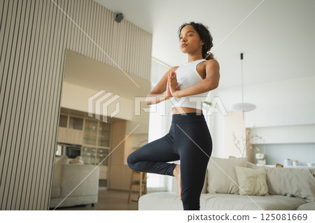 Yoga fitness workout training. Healthy African girl practicing yoga at home. Woman training Pilates doing sports exercise on yoga mat indoor. Girl have training workout for weight loss. Sport fitness Yoga fitness workout training. Healthy African girl practicing yoga at home. Woman training Pilates doing sports exercise on yoga mat indoor. Girl have training workout for weight loss. Sport fitness 125081669